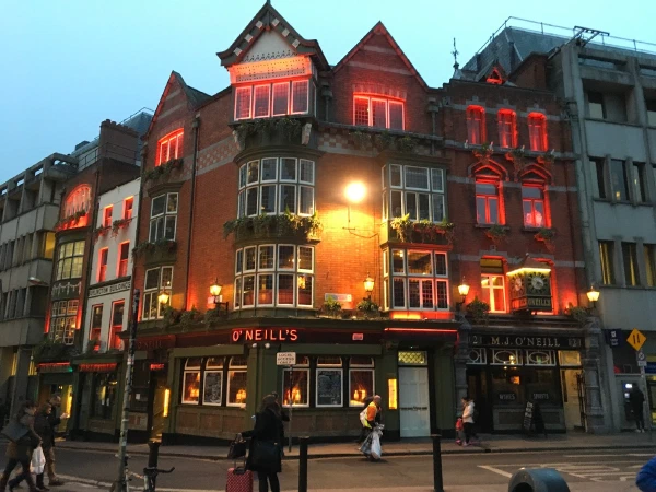 Lit storefronts on a Dublin street at dusk