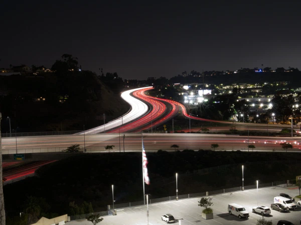 Long-exposure light trails on a curving freeway at night