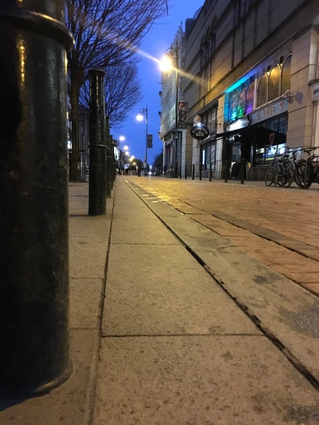 A Dublin sidewalk under blue streetlight